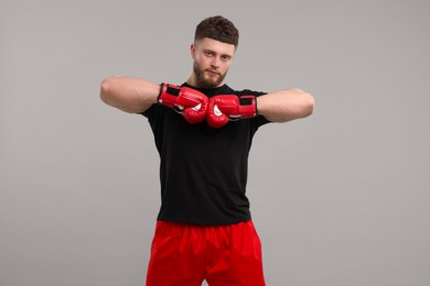 Photo of Man in boxing gloves on grey background