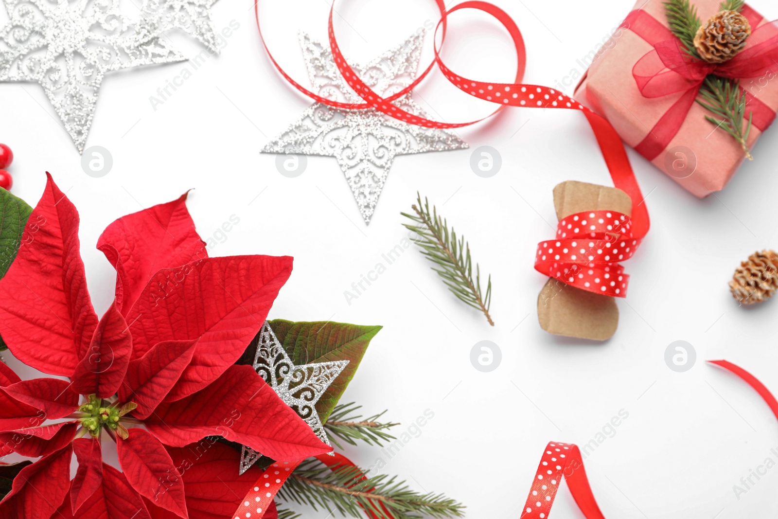 Photo of Flat lay composition with beautiful poinsettia and gift on white background. Christmas traditional flower