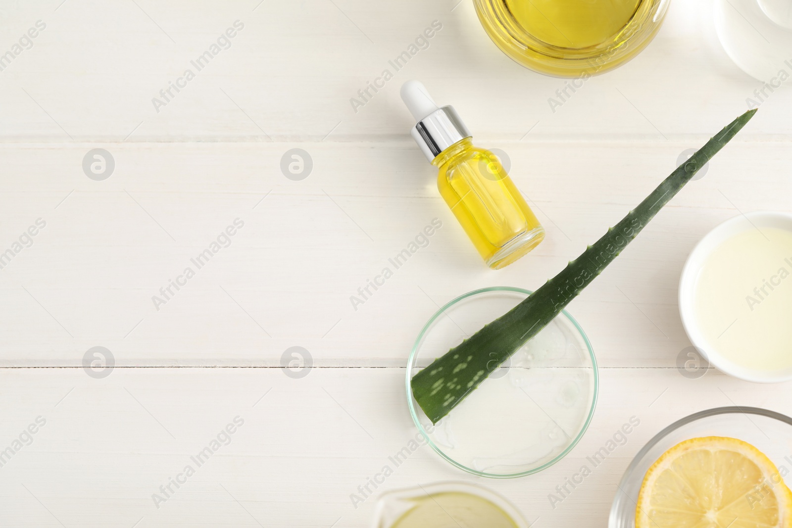 Photo of Flat lay composition with bottle of cosmetic oil on white wooden table, space for text