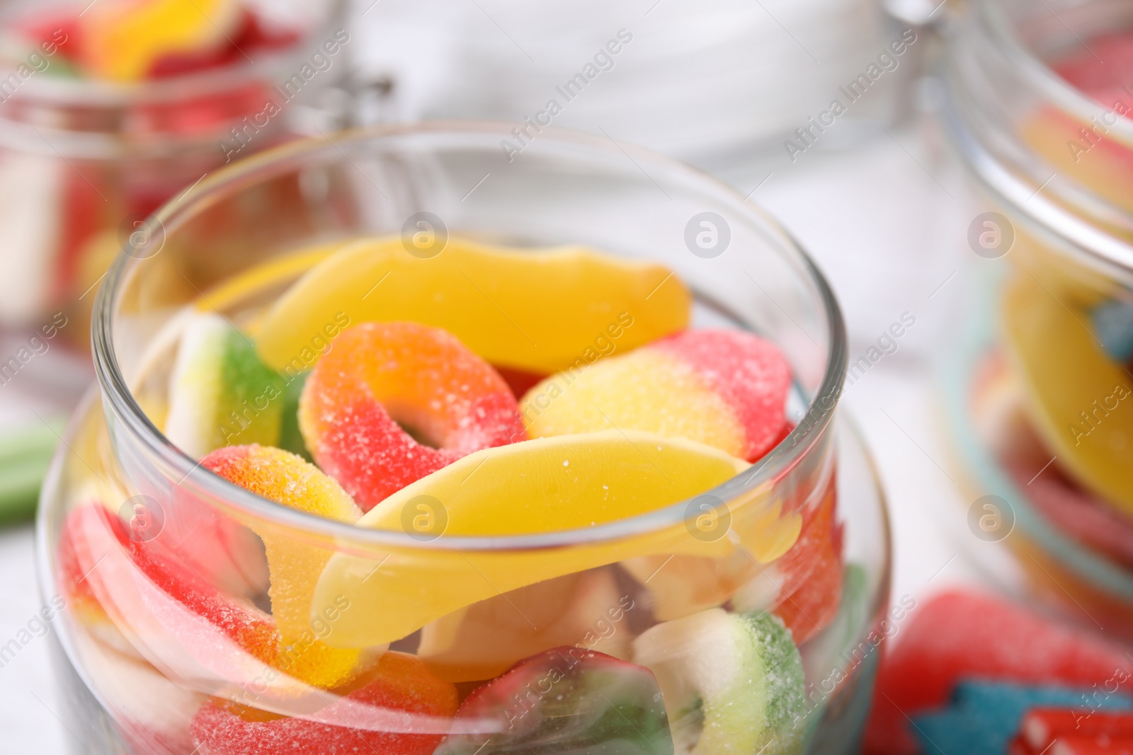 Photo of Tasty jelly candies in jars on table, closeup