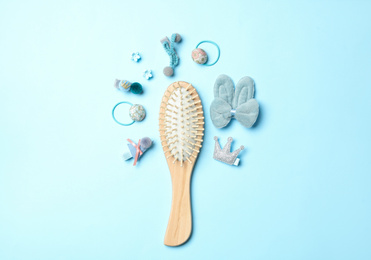 Photo of Flat lay composition with wooden hair brush on light blue background