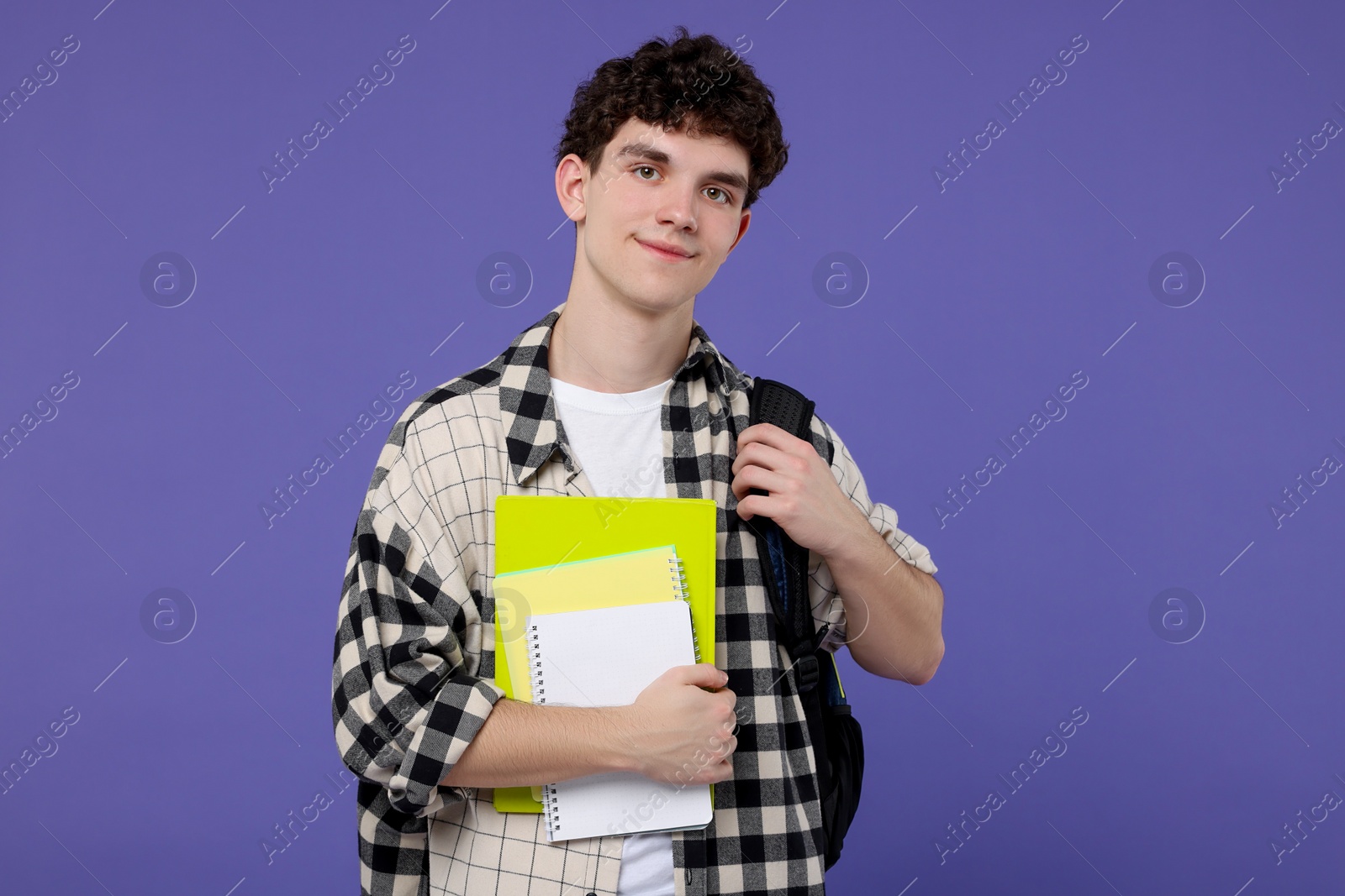 Photo of Portrait of student with backpack and notebooks on purple background