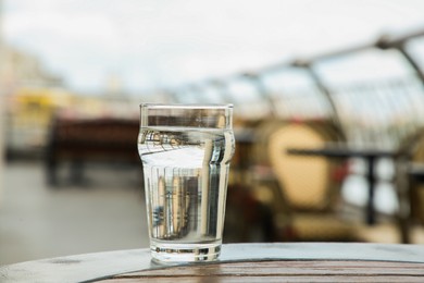 Glass of fresh water on table outdoors