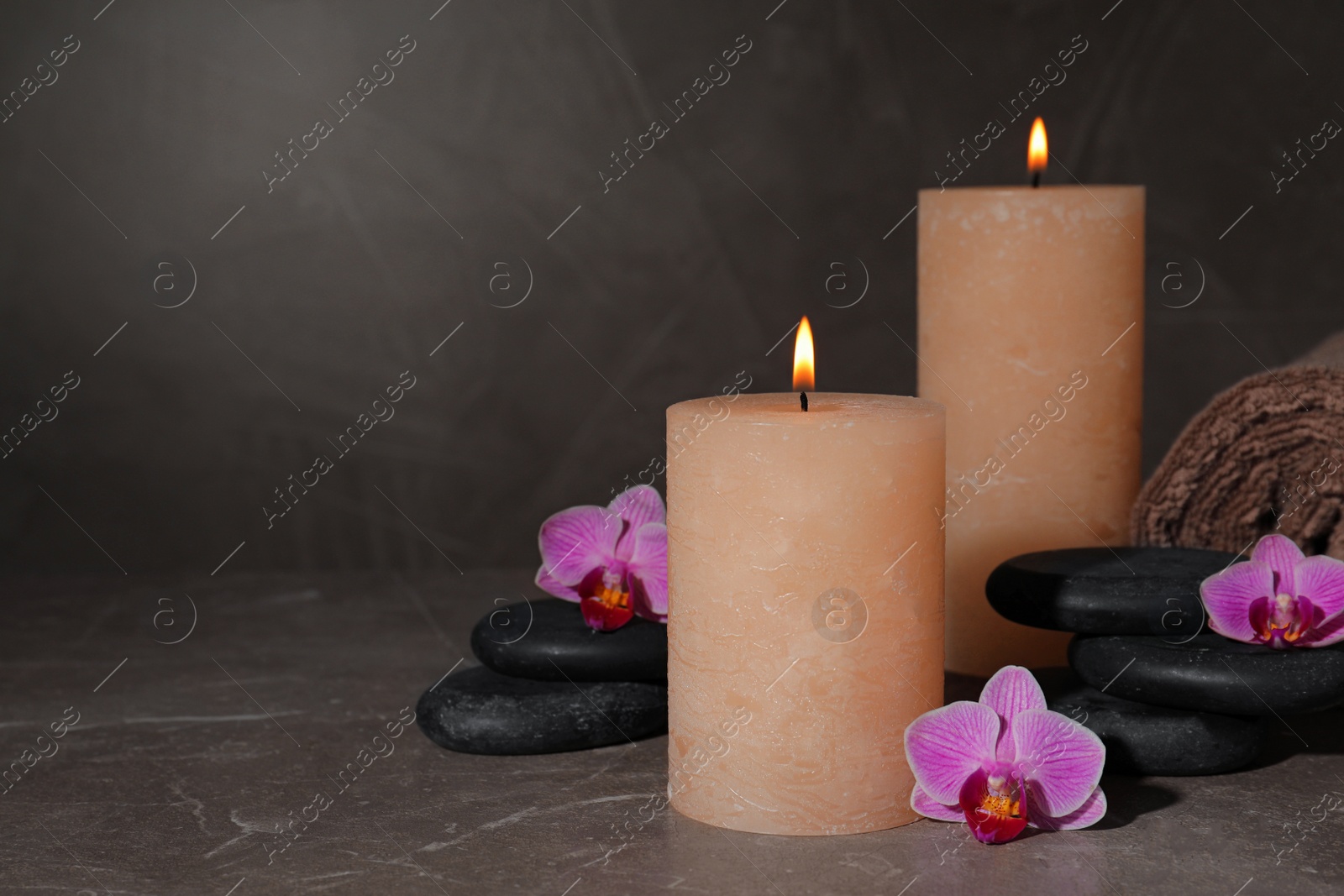 Photo of Composition with candles and spa stones on marble table. Space for text