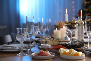 Photo of Christmas table setting with festive decor and dishware indoors