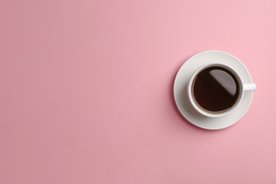 Photo of Ceramic cup with hot aromatic coffee on color background, top view