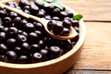 Photo of Fresh acai berries on wooden table, closeup