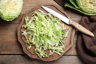 Cut fresh savoy cabbage on wooden table, flat lay