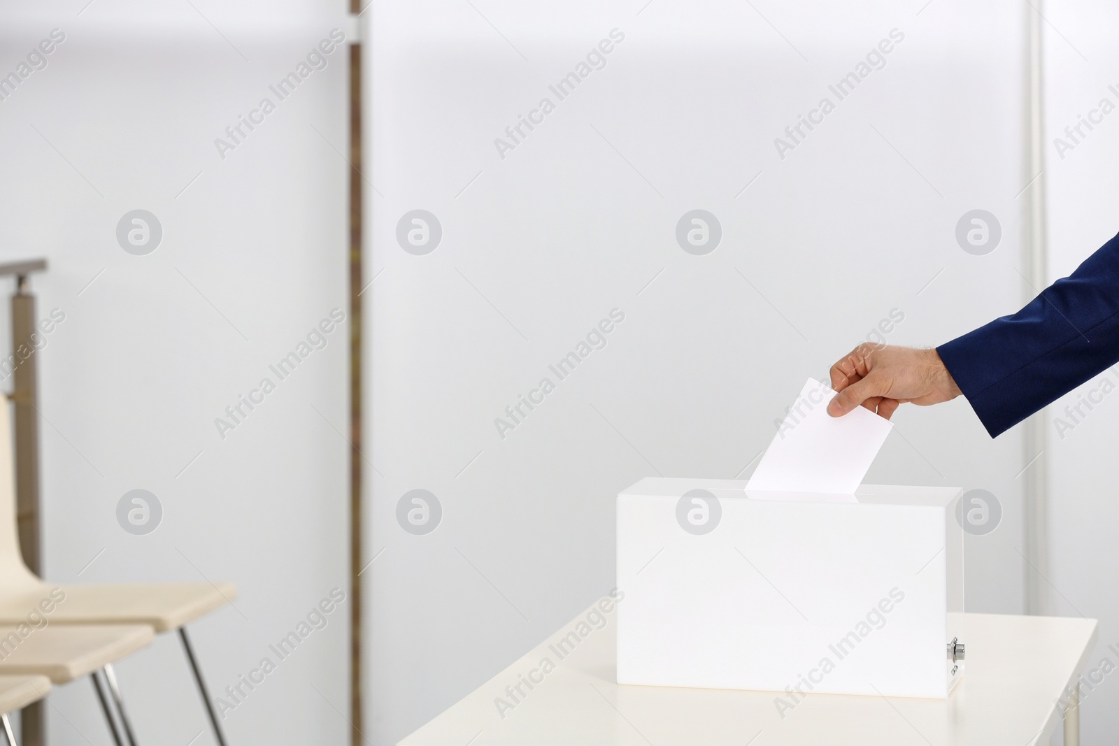 Photo of Man putting his vote into ballot box at polling station, closeup. Space for text