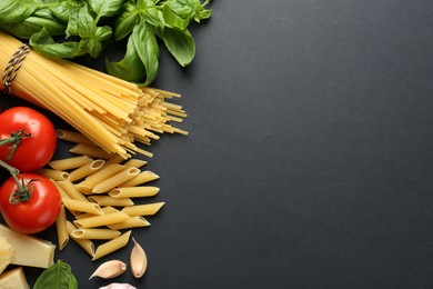 Photo of Different types of pasta, spices and products on black background, flat lay. Space for text