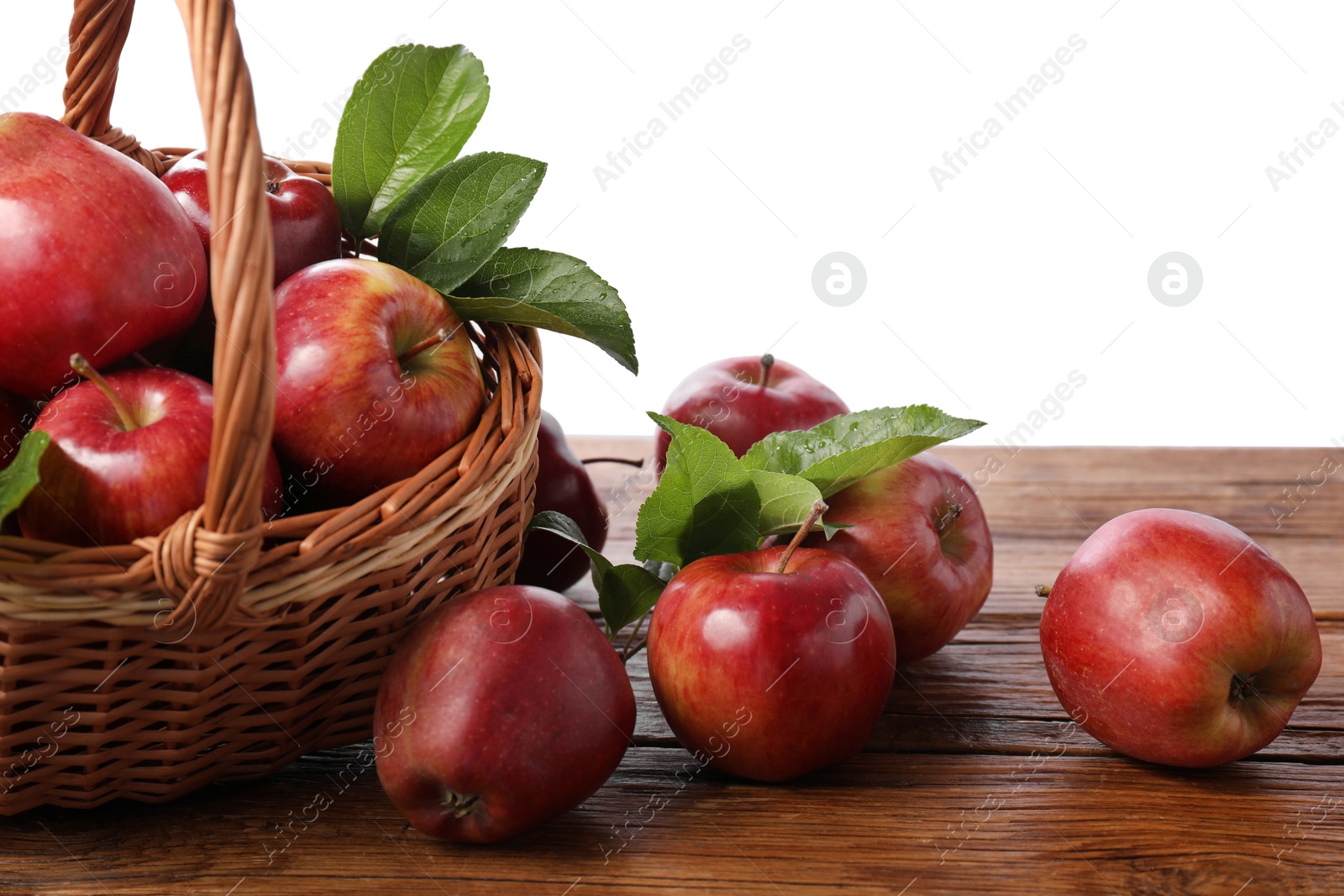 Photo of Ripe red apples and leaves on wooden table against white background