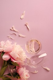 Photo of Glasses with rose wine and beautiful peonies on pink background, flat lay