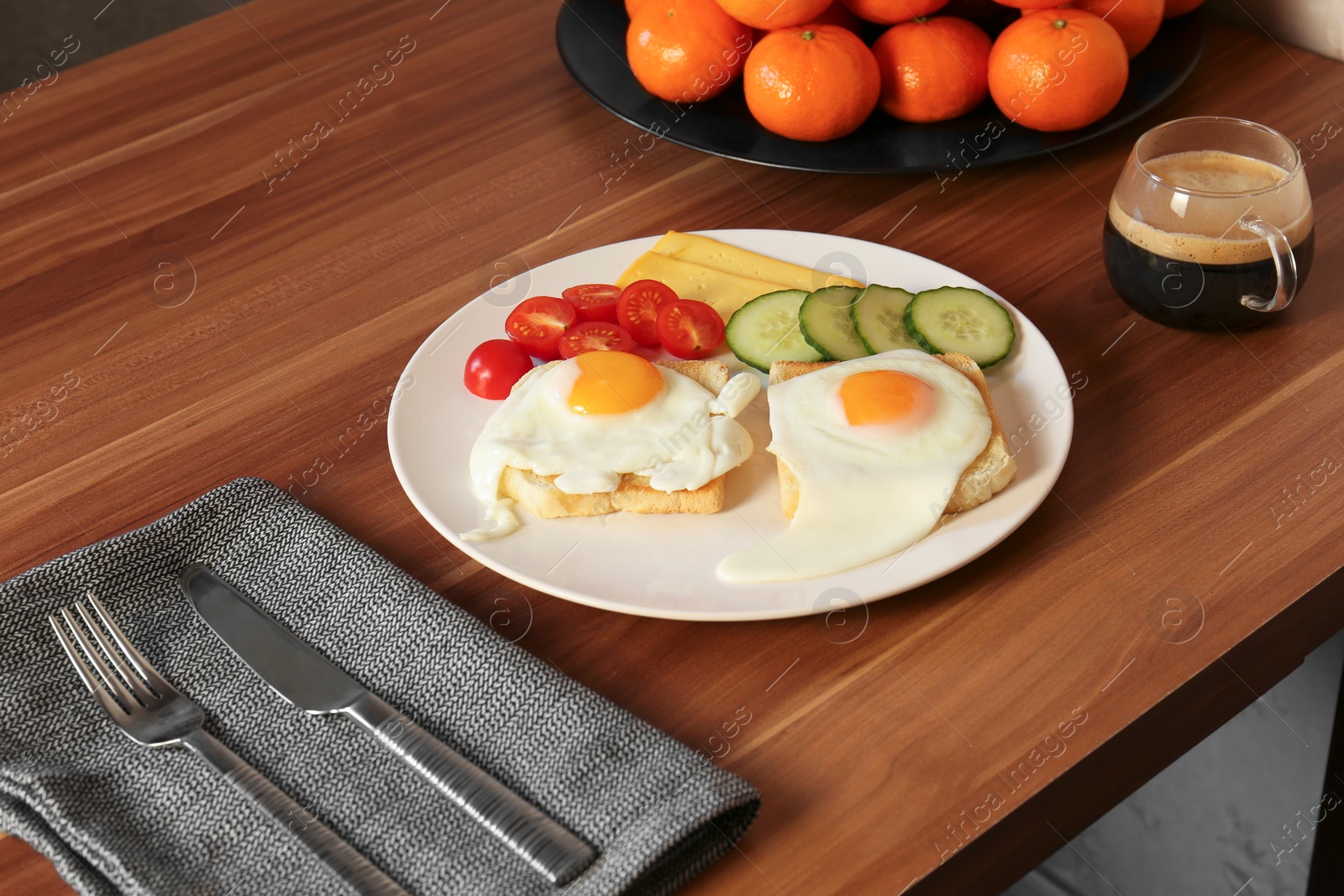 Photo of Tasty toasts with fried eggs, cheese and vegetables on wooden table