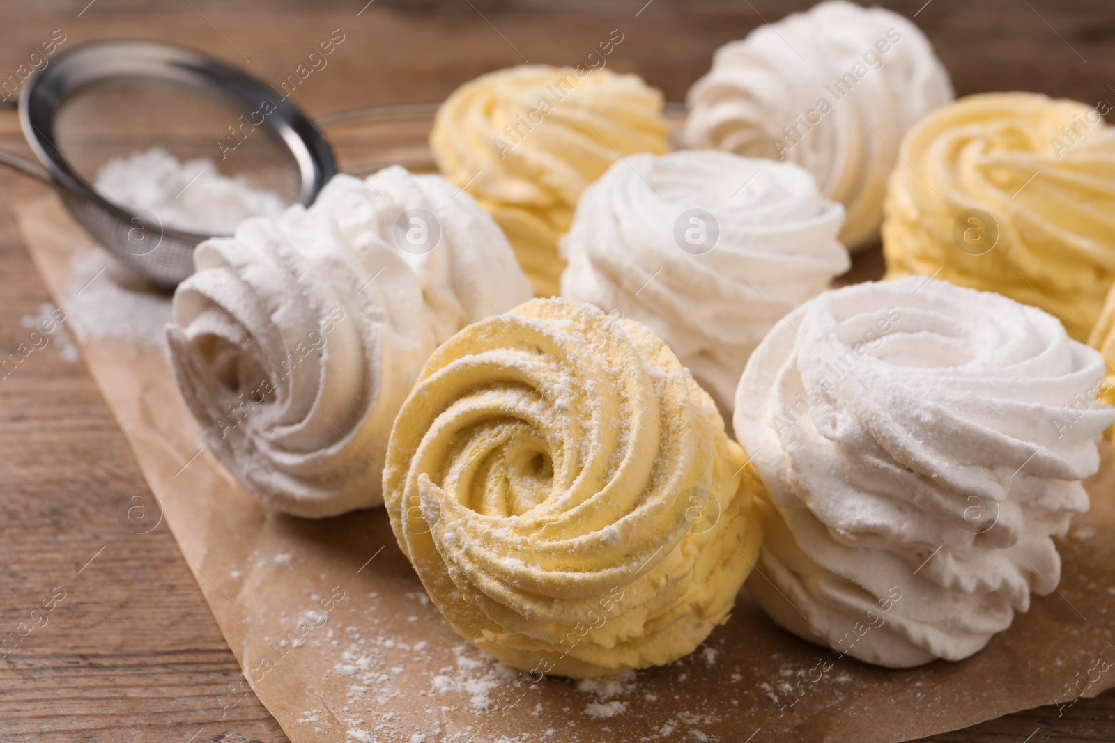 Photo of Delicious yellow and white marshmallows on wooden table, closeup