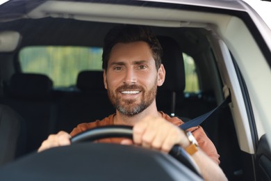 Enjoying trip. Happy bearded man driving car, view through windshield