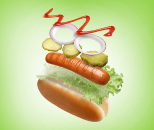 Image of Hot dog ingredients in air on green gradient background