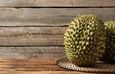 Photo of Ripe durians on wooden table. Space for text