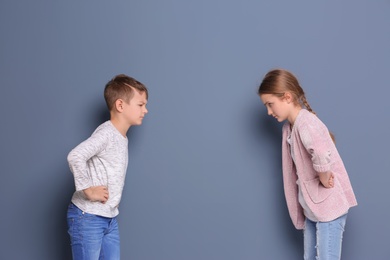 Brother arguing with sister on color background