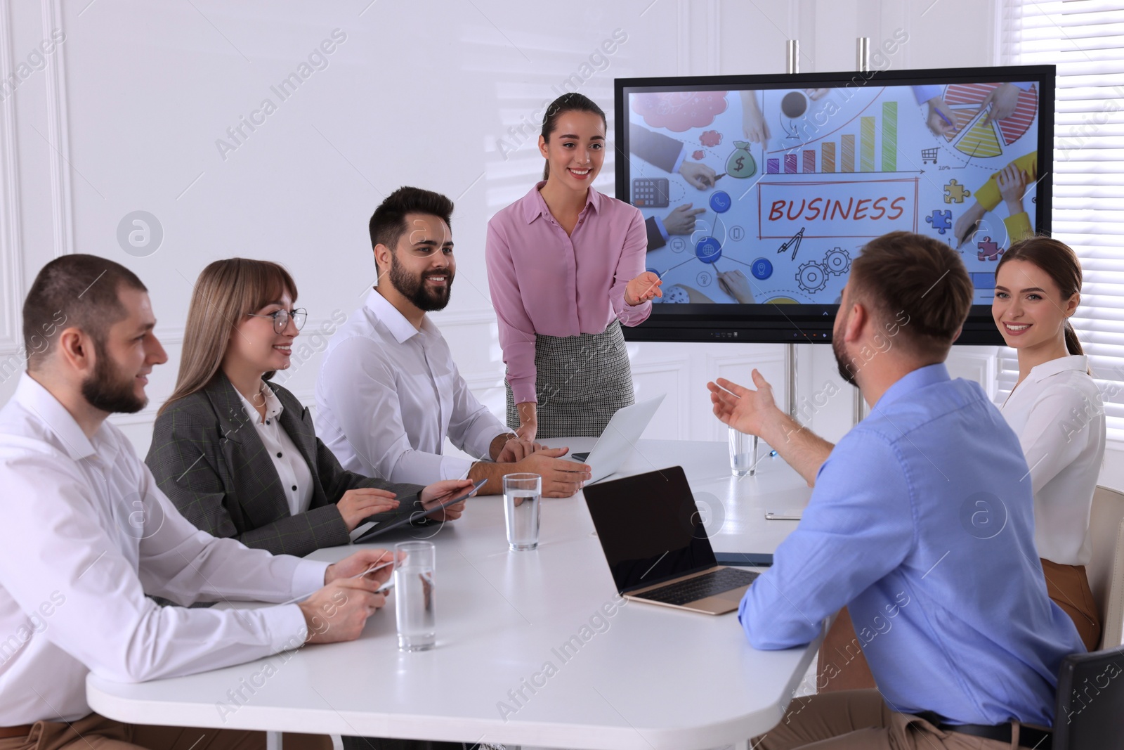 Photo of Business trainer near interactive board in meeting room during presentation