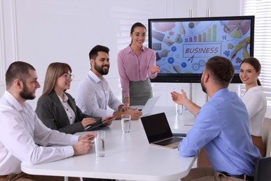 Photo of Business trainer near interactive board in meeting room during presentation