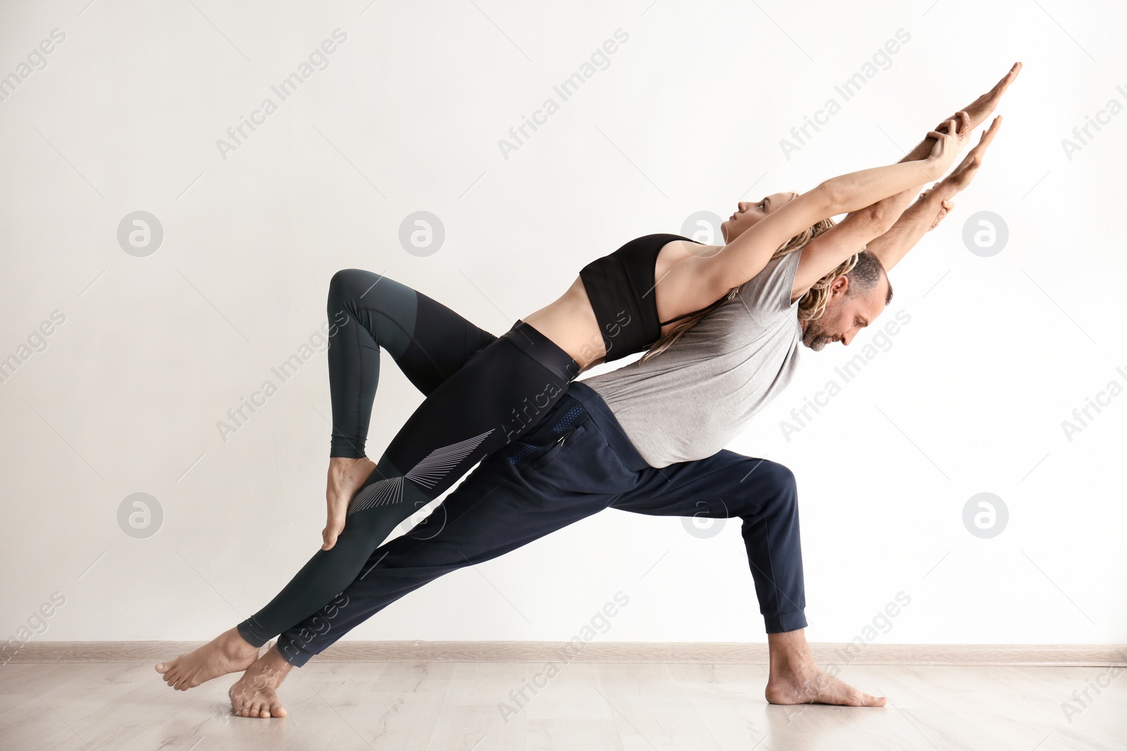 Photo of Man and woman practicing yoga indoors