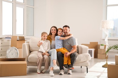 Happy family sitting on couch in new apartment. Moving day