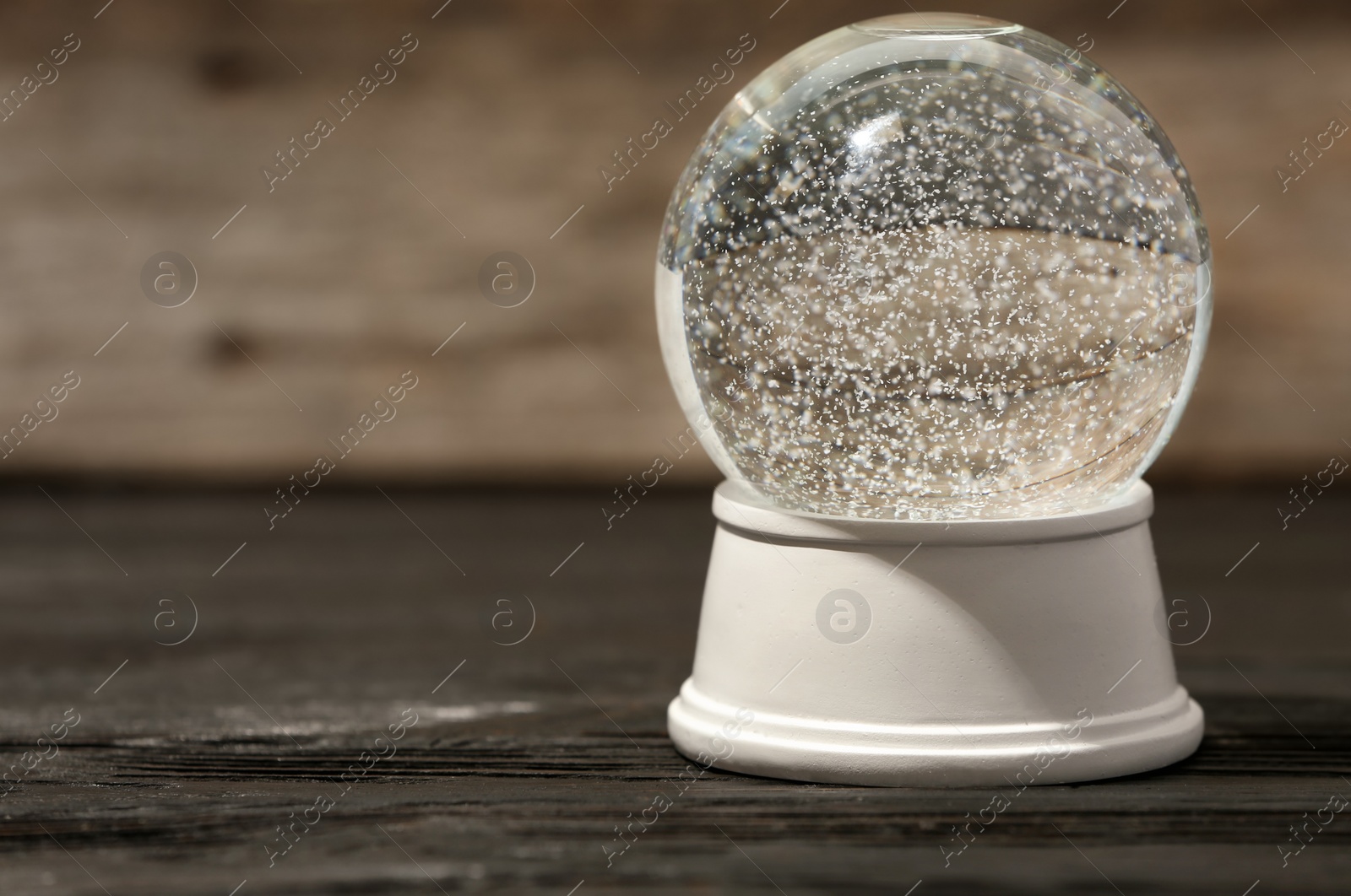 Photo of Magical empty snow globe on wooden table. Space for text