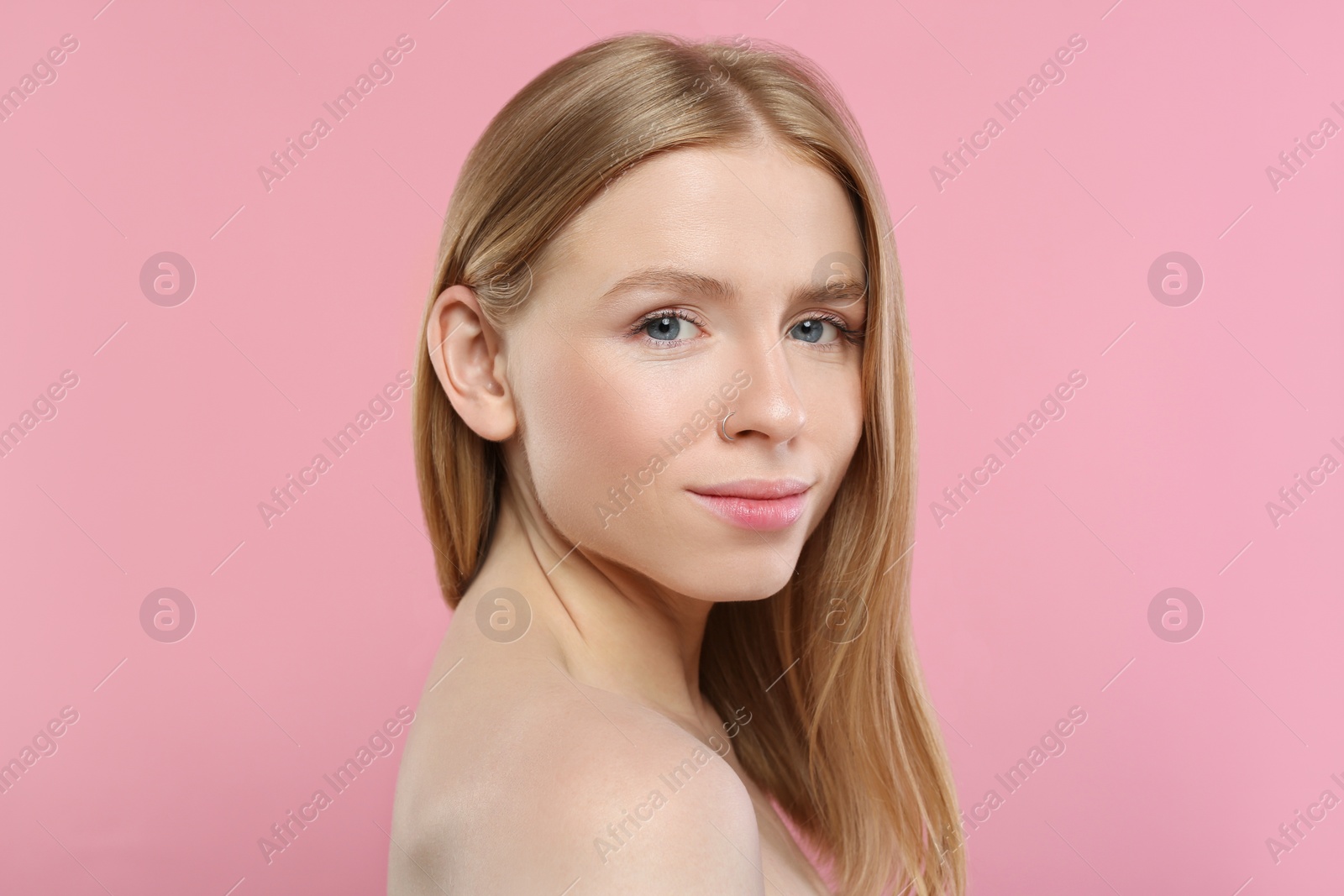 Photo of Portrait of beautiful young woman on pink background