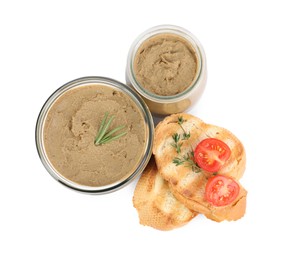 Photo of Glass jars with tasty liver pate, bread and tomato on white background, top view