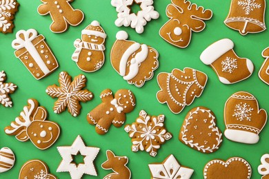 Photo of Different Christmas gingerbread cookies on green background, flat lay