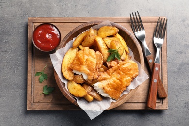 Photo of Tasty British traditional fish and potato chips on table, top view