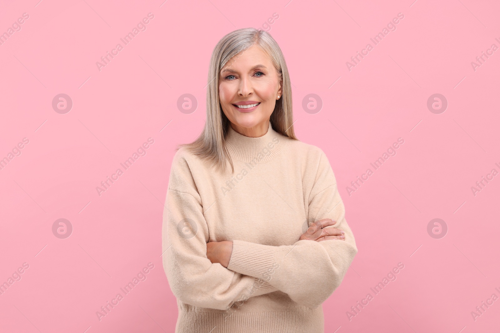 Photo of Portrait of beautiful middle aged woman on pink background