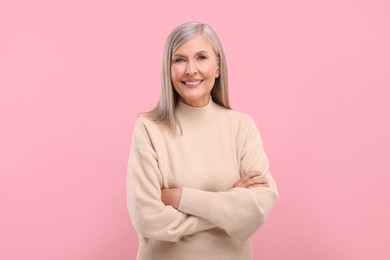 Portrait of beautiful middle aged woman on pink background