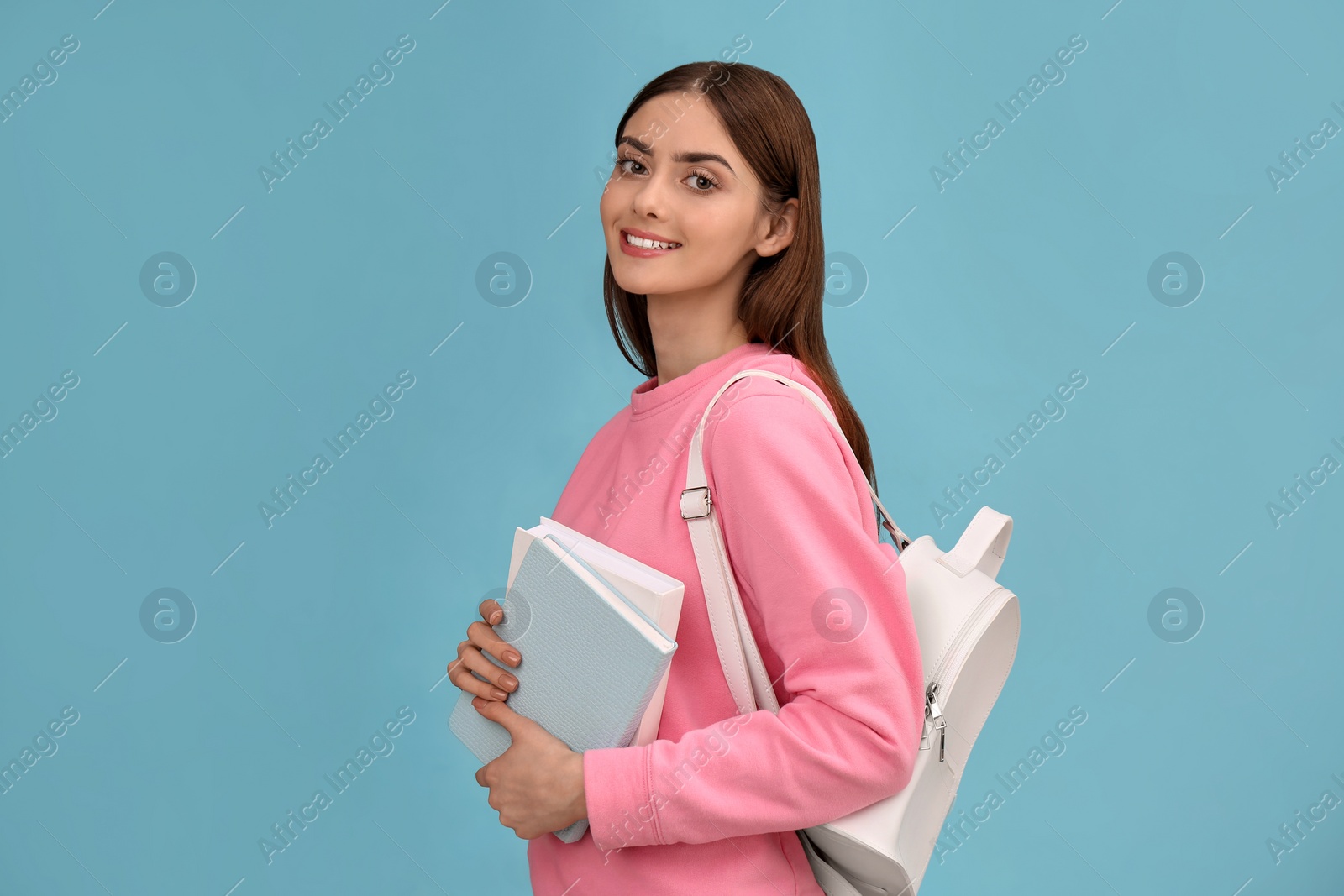 Photo of Teenage student with books and backpack on turquoise background