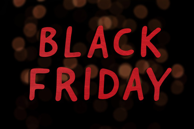 Image of Phrase Black Friday and blurred view of beautiful lights on background 