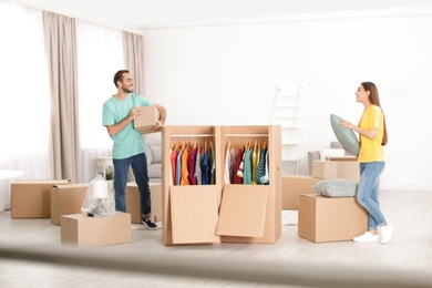 Young couple near wardrobe boxes at home