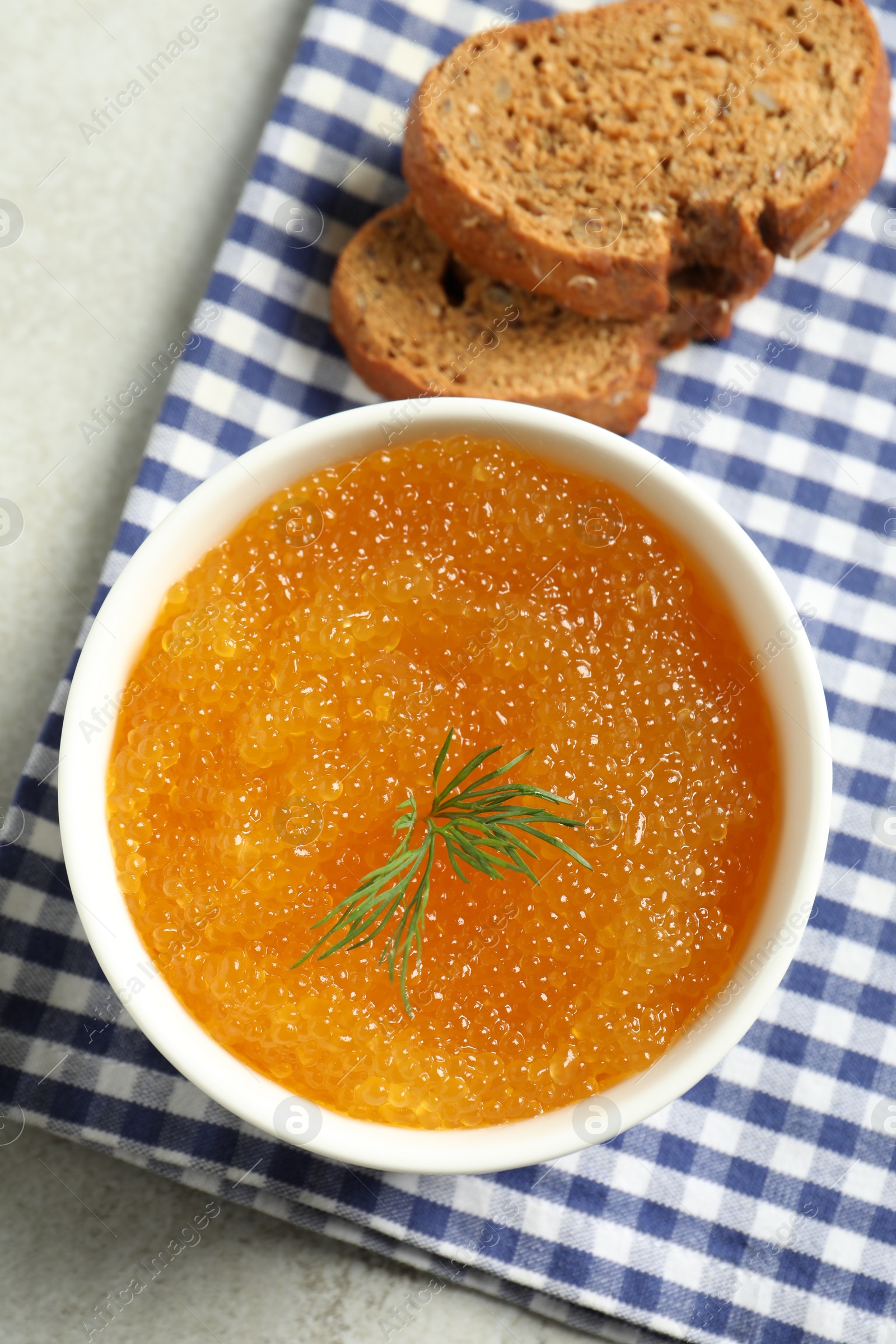 Photo of Fresh pike caviar in bowl and bread on light grey table, top view