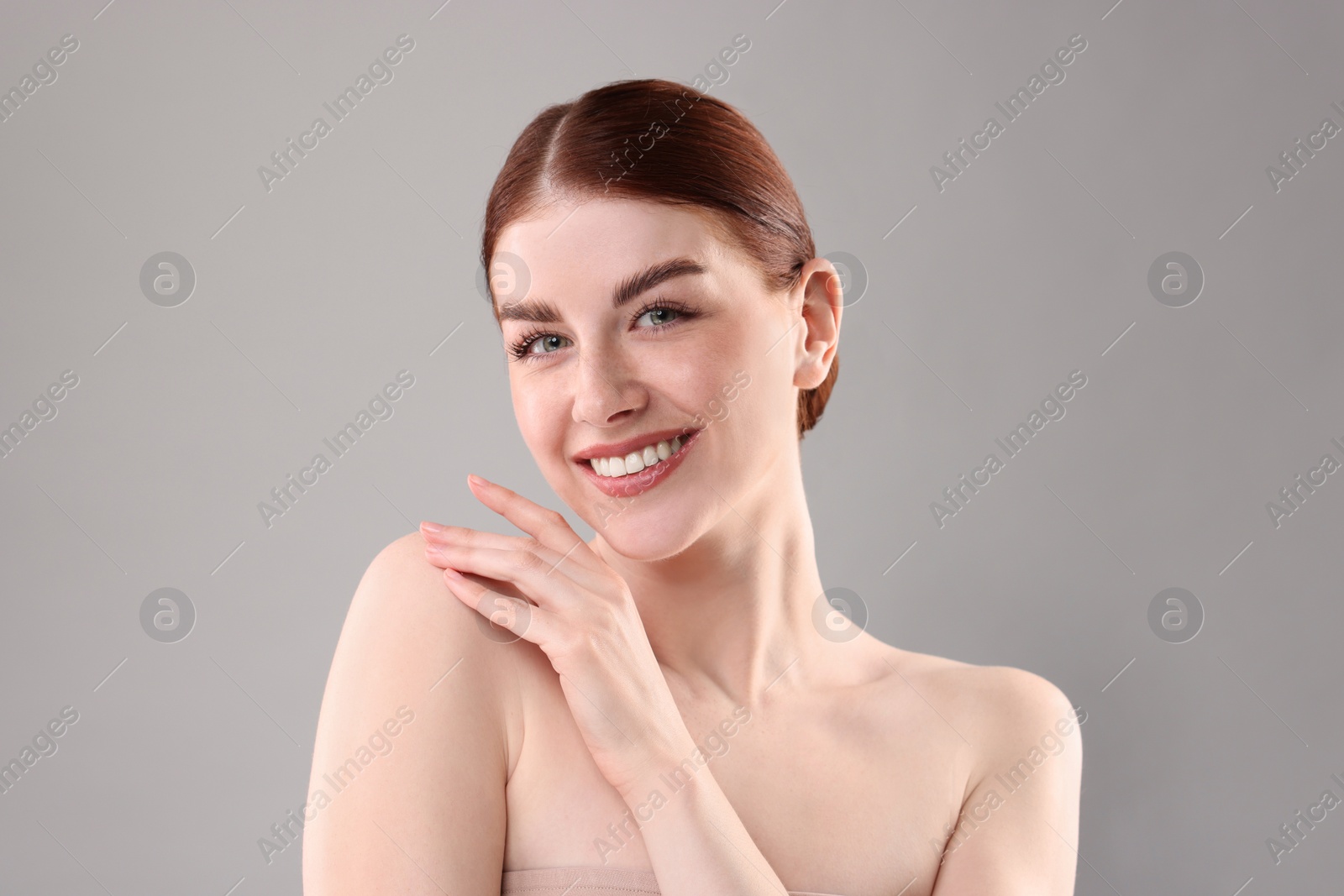 Photo of Portrait of smiling woman on grey background