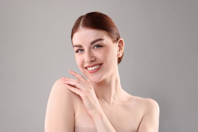 Portrait of smiling woman on grey background