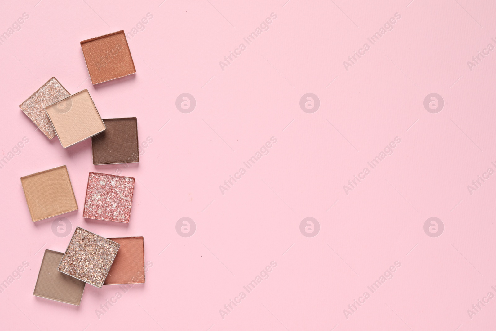 Photo of Different beautiful eye shadows on pink background, flat lay. Space for text