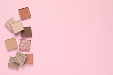 Photo of Different beautiful eye shadows on pink background, flat lay. Space for text