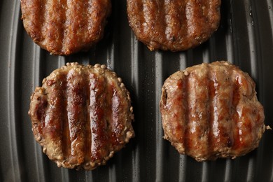 Photo of Delicious hamburger patties cooking on electric grill, top view