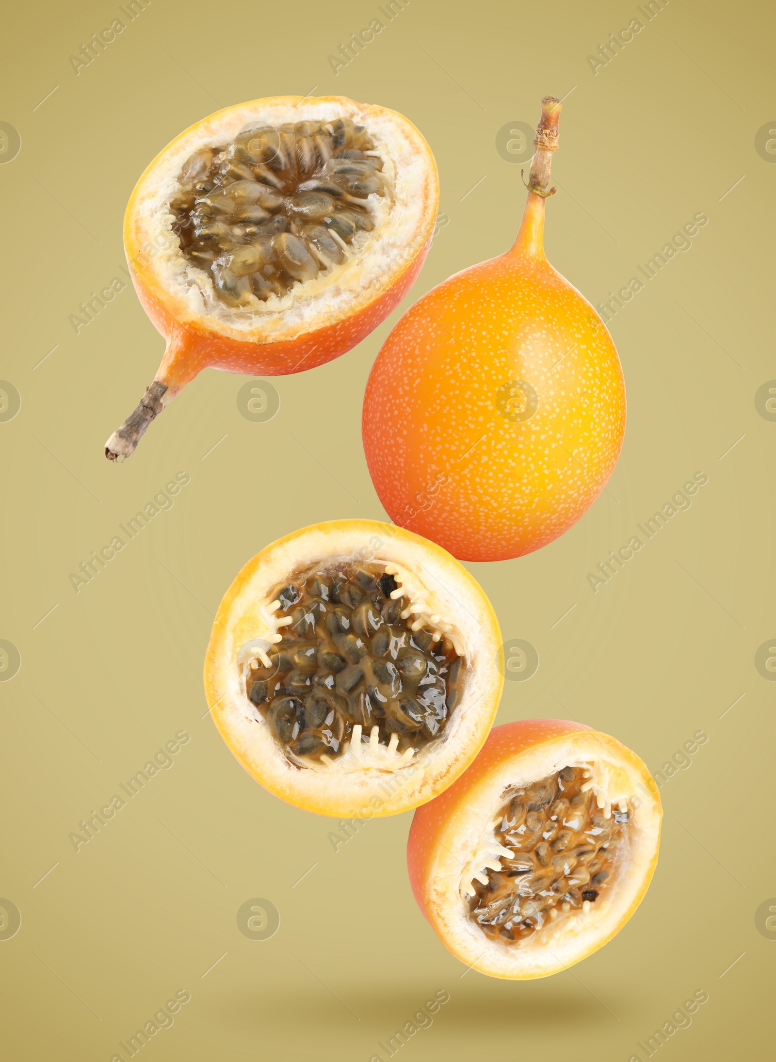 Image of Delicious ripe granadillas falling on color background