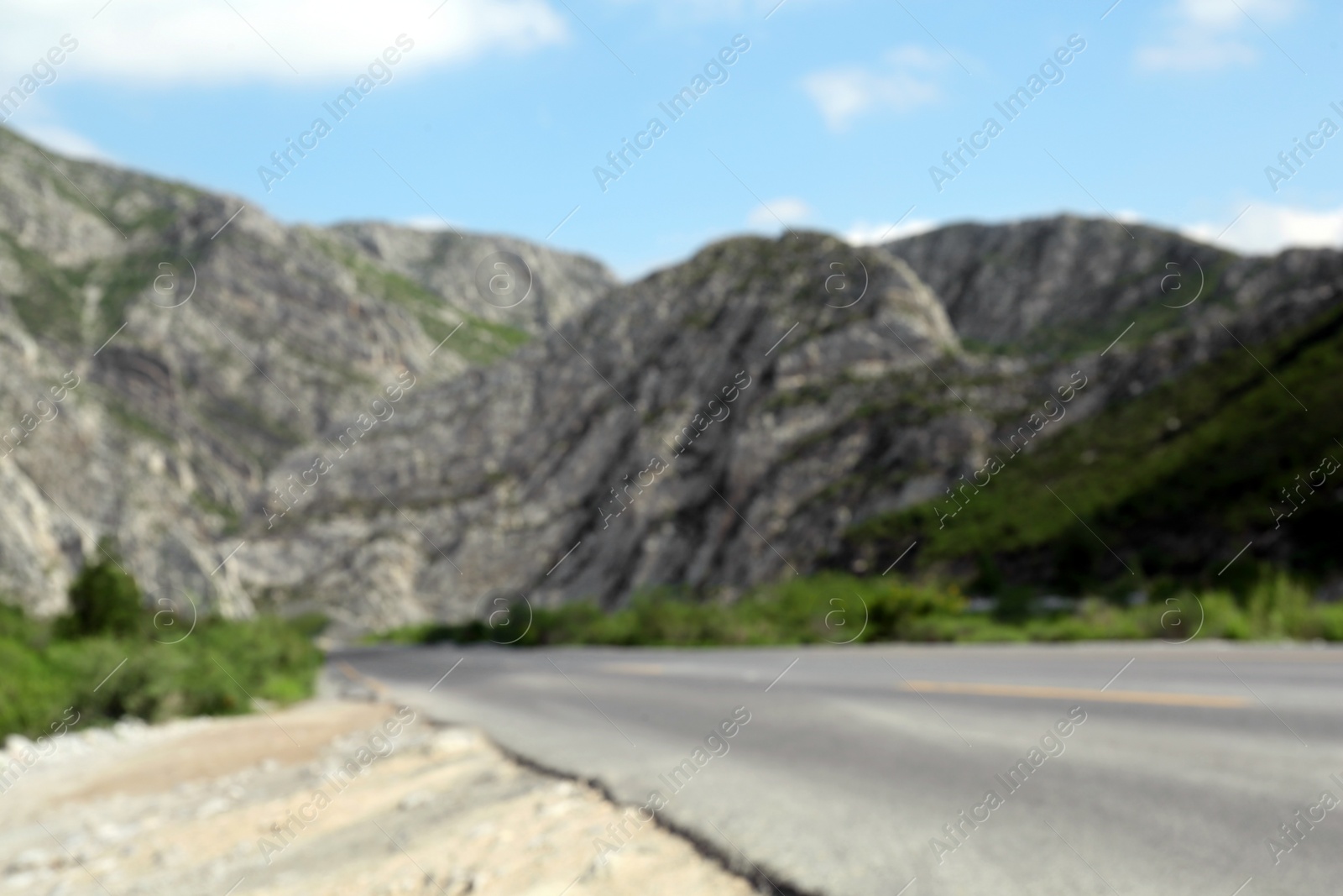 Photo of Picturesque view of big mountains and bushes near road