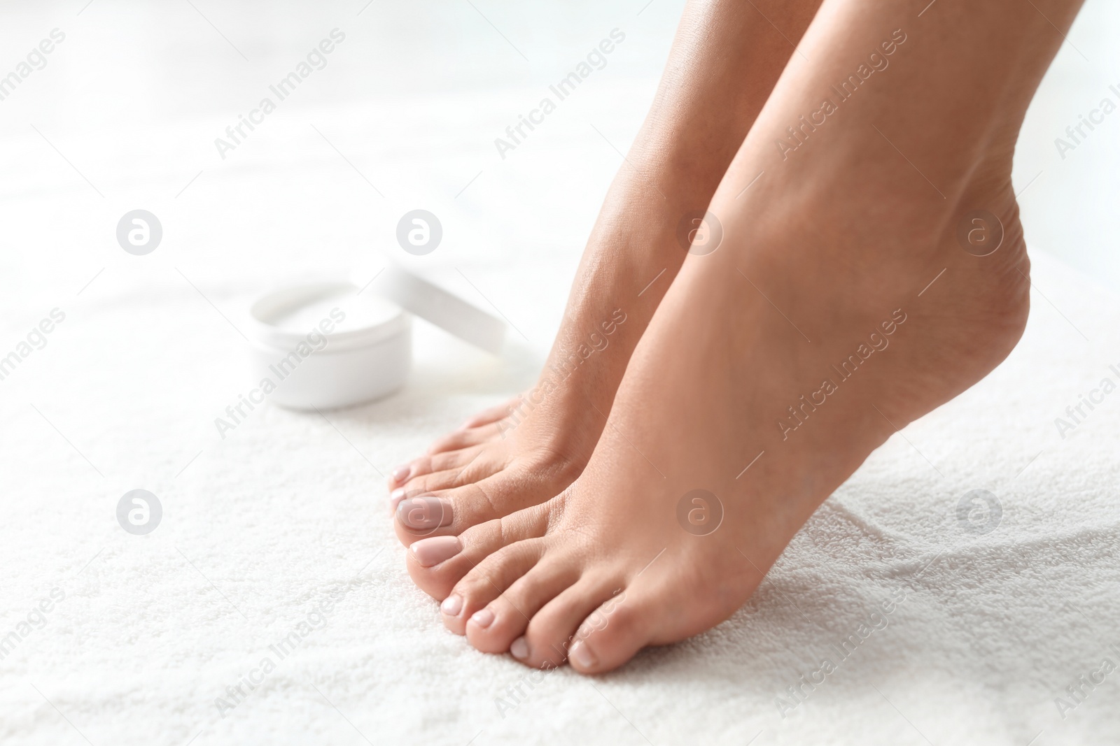 Photo of Woman with beautiful feet on white towel, closeup. Spa treatment