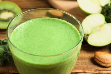 Photo of Tasty fresh kale smoothie on wooden table, closeup