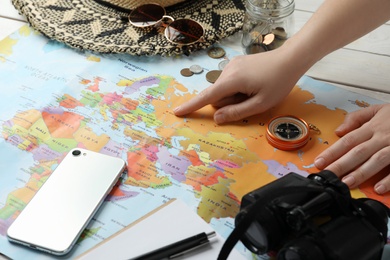 Photo of Woman with world map at table, closeup. Travel during summer vacation