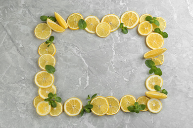 Photo of Frame made with ingredients for lemonade on grey marble background, top view. Space for text