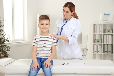 Photo of Children's doctor examining patient with stethoscope in hospital