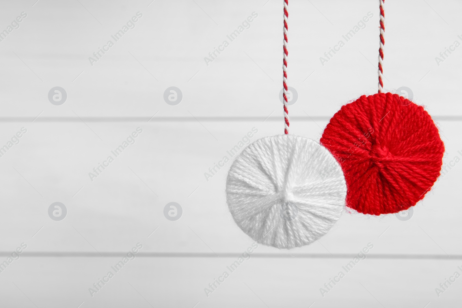 Photo of Traditional martisor on white wooden background, space for text. Beginning of spring celebration